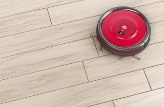 roter Saugroboter auf Holzboden